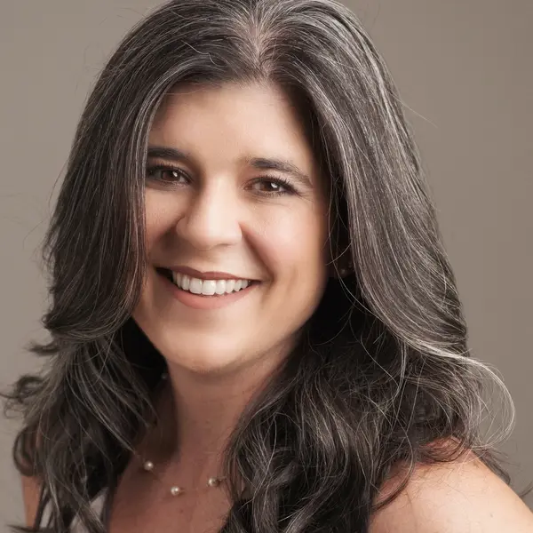 A woman with long hair smiling for the camera.