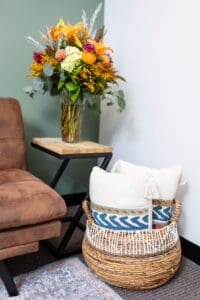 A living room with flowers and a chair